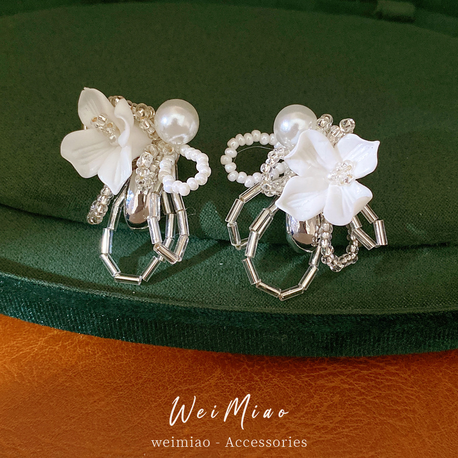 Agujas de plata flores gota de agua perlas personalidad exquisita nicho temperamento pendientes ligeros de lujo alta sensación de pendientes mujeres al por mayor