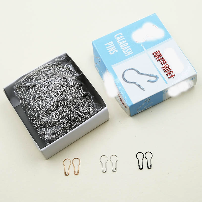 Оптовый магазин одежды: подвесные бирки, маленькие железные булавки для фиксации одежды, разноцветные булавки-тыквы, застежки.