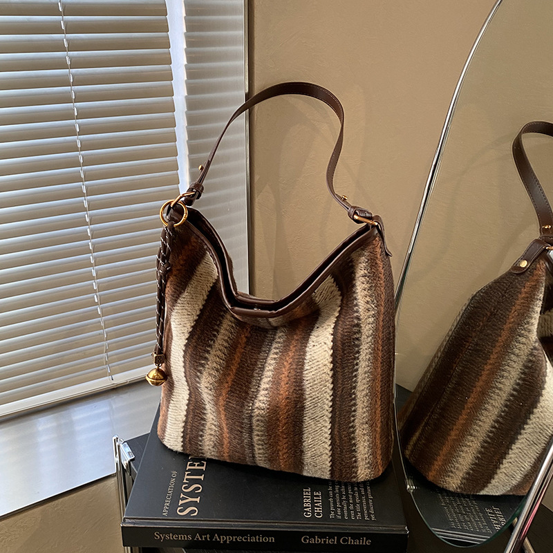 Bolsa de cubo de tendencia coreana a rayas, bolsa de hombro de gran capacidad, otoño y invierno 2025, nueva bolsa de mochila casual para mujeres.