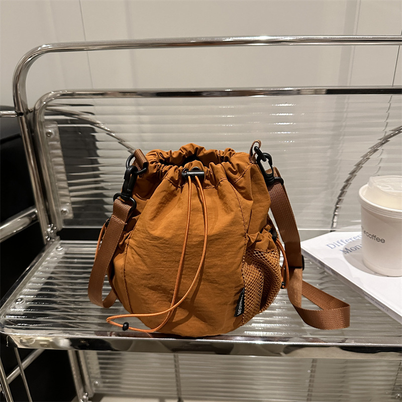 2025 verano nuevo nicho japonés y coreano tirar de la correa de tela de un hombro mochila de mujer ligera perezosa bolsa de cubo de feng shui