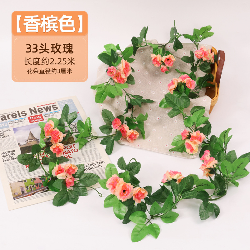 Simulación de flores falsas rosas de caña colgando la pared tubería de drenaje envuelta hoja verde que cubre la parte superior de la decoración de boda de plástico