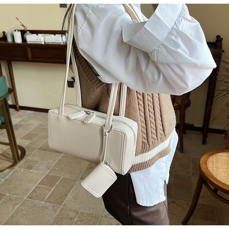 The 2024 new women's single-shoulder underarm bag is a simple and elegant commuting bag with a Korean-style niche design sense. It's a small square bag undefined