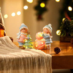 新しいクリスマスの装飾は陶磁器の彩色を飾ってクリスマスの男の子の女の子の夜の明かりを飾ってクリスマスツリーの祝日のプレゼントを飾った