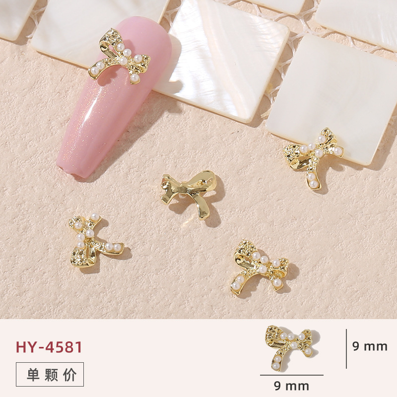 Uñas mariposa joyería nueva línea popular perla arco metal decoración de uñas pequeños accesorios de joyería al por mayor