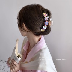 かわいい金持ちのマージャンは髪飾りを挟んでいます。