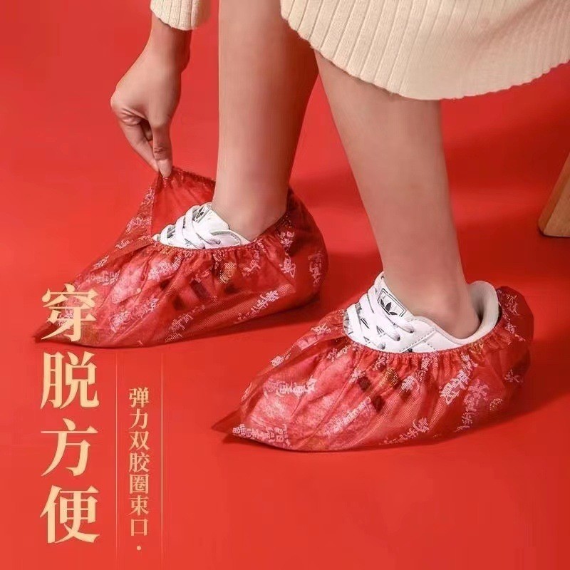 A red disposable, thickened, indoor anti-slip, wear-resistant children's universal non-woven shoe cover with auspicious patterns.