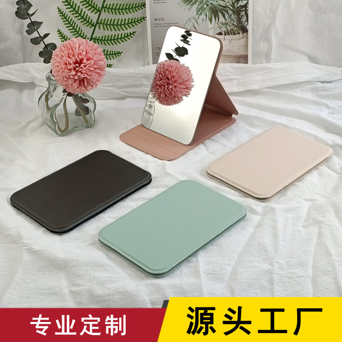 En stock al por mayor de mano plegable de escritorio pequeño espejo PU espejo de maquillaje portátil espejo de escritorio se puede personalizar logo