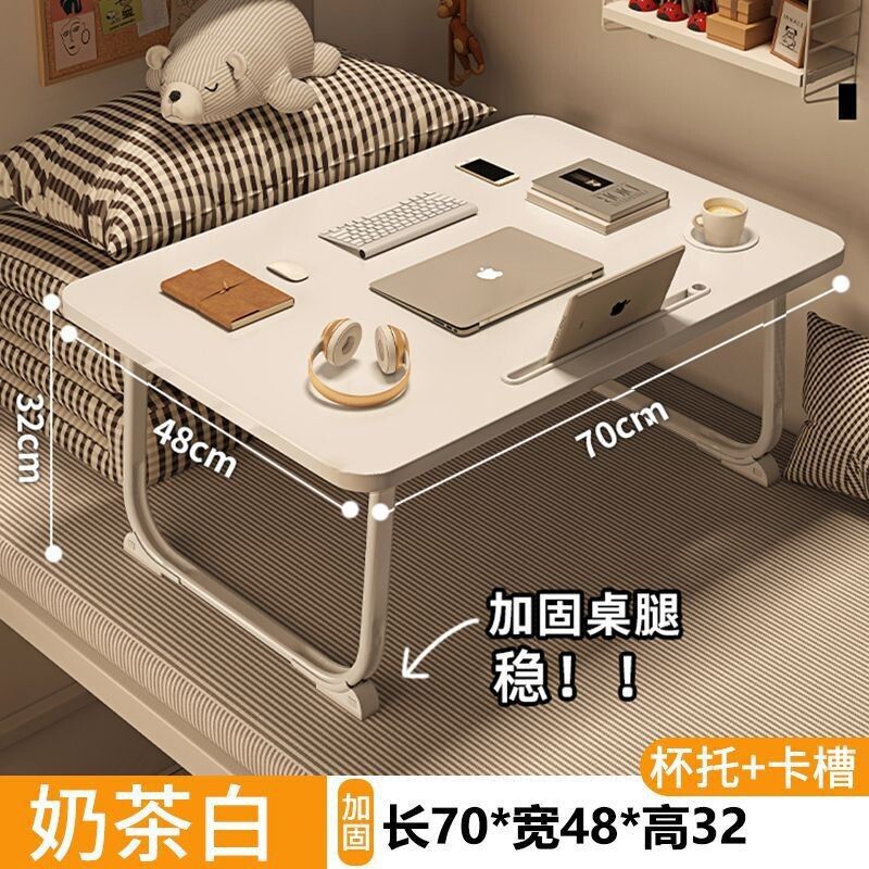 ベッドの上の小さい机のノートパソコンの机の上で折り畳みます。|undefined