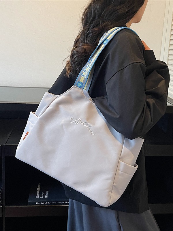 Bolsas de lona de moda de gran capacidad para mujeres 2026 nueva textura bordada letras bolsas de hombro de viaje simple bolsas de mano