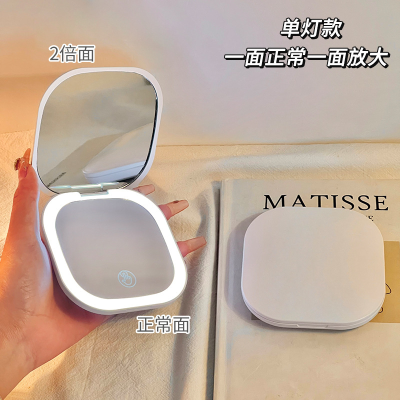化粧鏡携帯小鏡女性はledを持っています。|undefined
