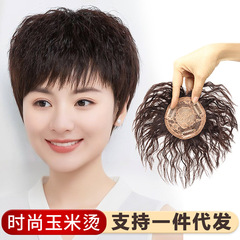 頭の上で髪を直します。女性のショートヘアのトウモロコシは全真の髪にパーマをかけます。