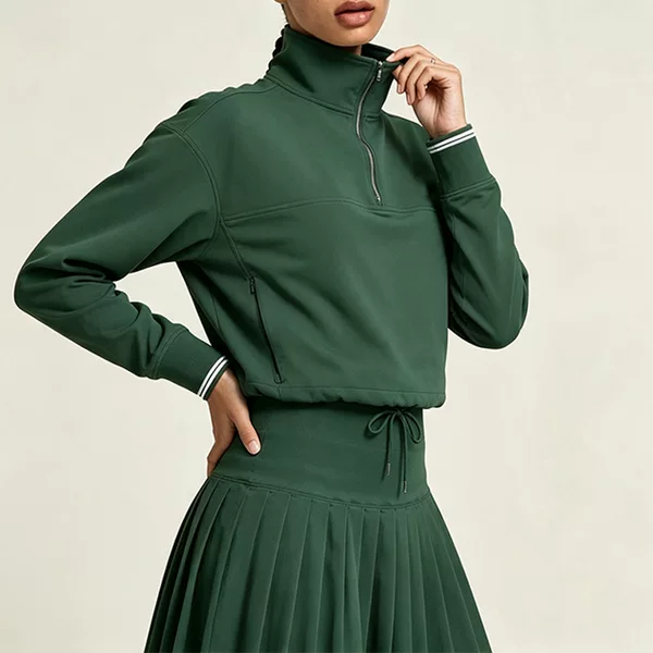 Half-zip, stand-up collar, short-length athletic sweatshirt for women, featuring color-blocked ribbed cuffs, suitable for golf, tennis, and casual wear, and offering wind protection