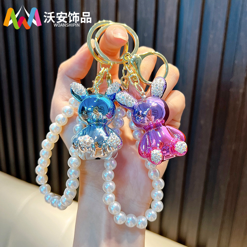 Cadena de perlas con incrustaciones de diamantes llavero de conejo bolso de muñeca colorido colgante llavero de coche máquina de muñecas regalo al por mayor