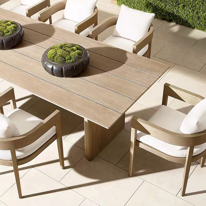 Solid wood dining table and chairs made from weather-resistant teak with an aged finish, perfect for outdoor patios, villas, gardens, and leisurely outdoor gatherings.