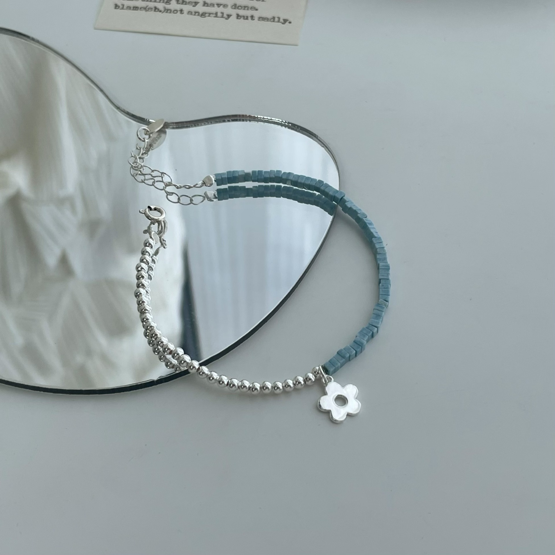 Model wearing the dainty half beaded flower charm necklace