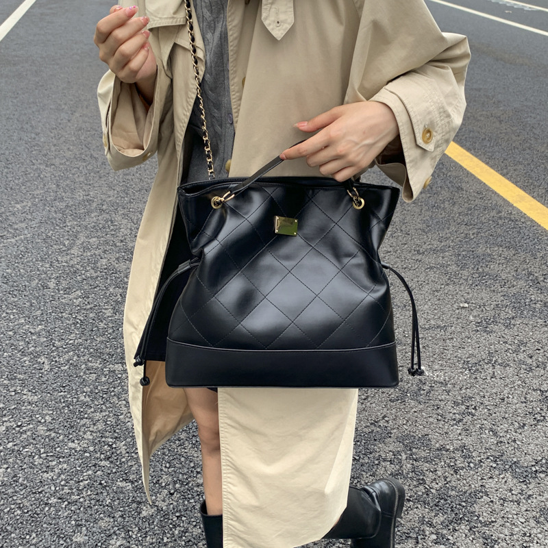 Bolsa de cadena de diamante transfronteriza retro bolso de cubo de agua mujer otoño y invierno 2025 nuevo empalme mochila de hombro de viaje