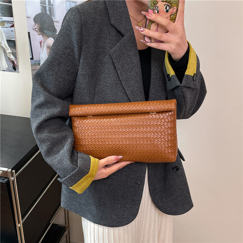 2025 otoño popular trenzado PU bolsos de muñeca bolsos de moda simple bolsos de maquillaje de gran capacidad coreana