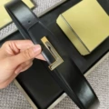 Gold base with gunmetal plate buckle, black flat grain strap, 3.8cm wide