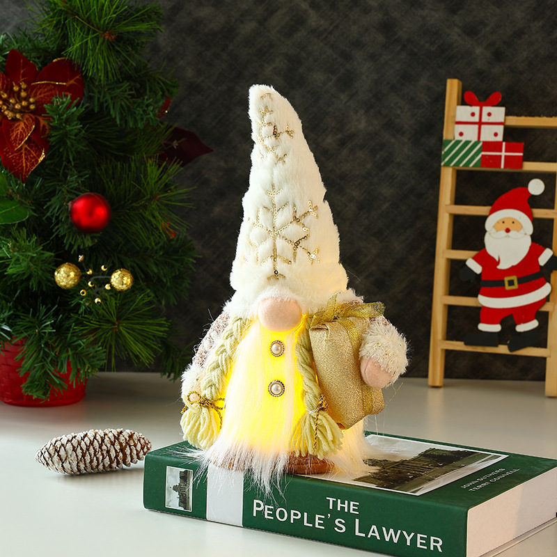 新しいクリスマス装飾の長いひげのぬいぐるみが光るプレゼントの杖を持ってサンタクロースの顔のない人形が飾られている|undefined