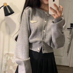 春秋の新型高級感のある灰色の柔らかいモチモチのニットのカーディガンの女性のデザイン感の小さい大衆のゆったりしている短いセーターのコート