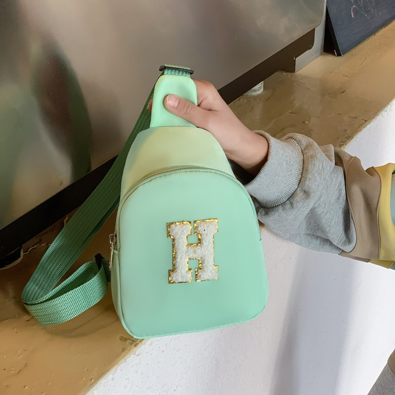 2026 nuevo bolso infantil de comercio exterior letras de moda coreana bolso de pecho para niños y niñas bolso de cinturón casual de color sólido