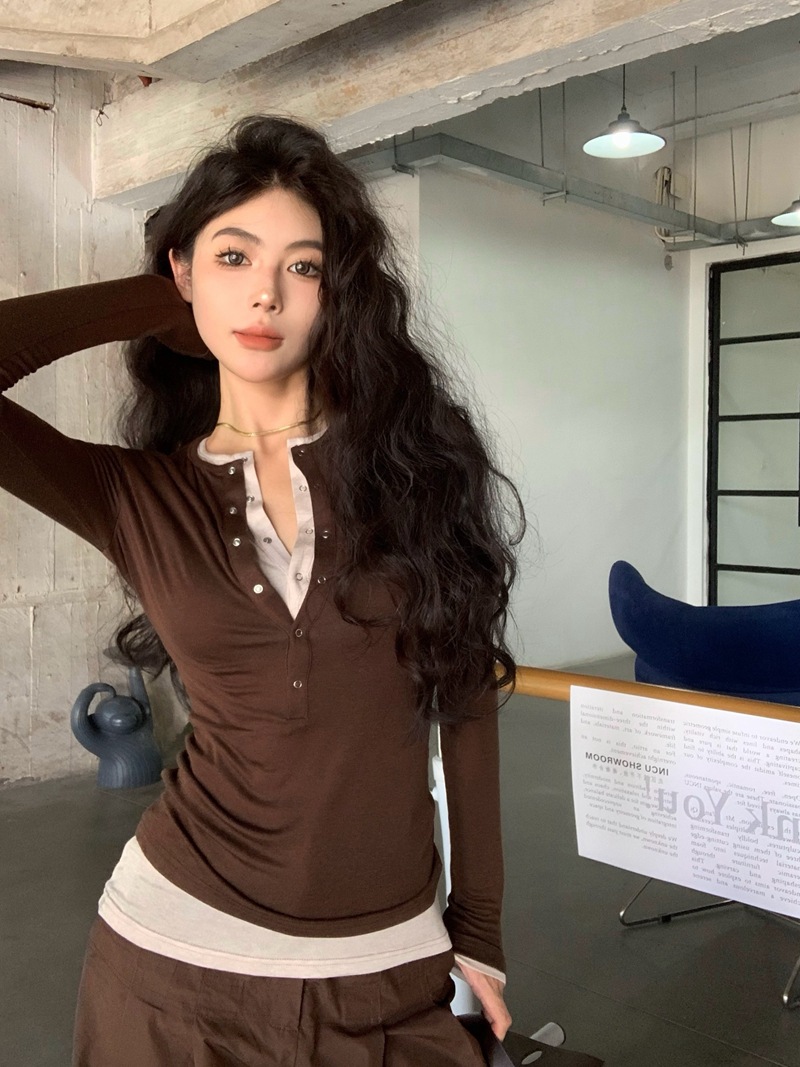 偽の2つのつなぎ合わせの色の長袖のtシャツの女性の秋の修身はやせている底のシャツのデザイン感の気質の百合の上着を現します。