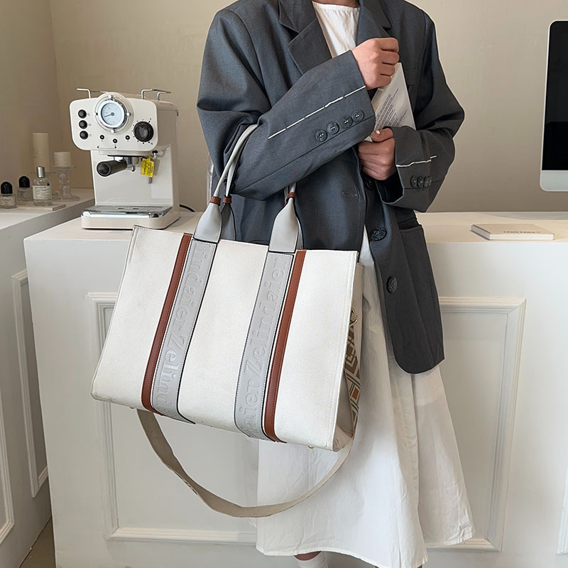 Bolso tote de lona de nuevo estilo con bloques de color, de gran capacidad para mujer, bolso cruzado de moda transfronteriza con sensación de alta gama para el trabajo y el transporte diario.