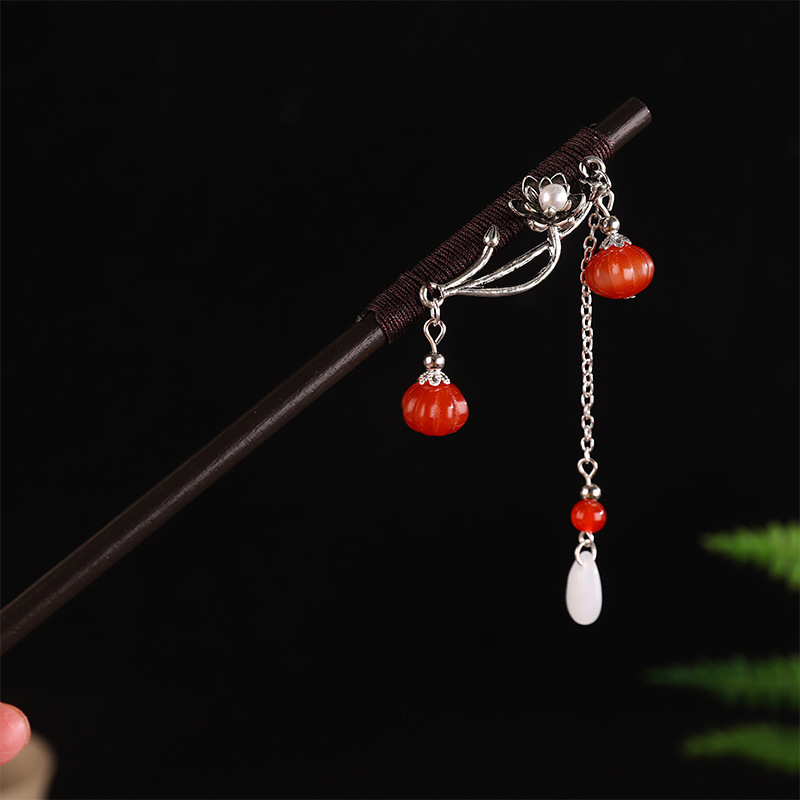 A small red pumpkin hairpin