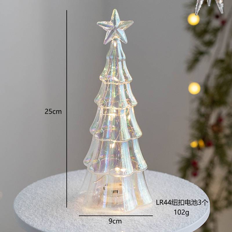 クリスマスツリーの家庭用デスクトップの置物が光る夜の明かりを飾ってクリスマスプレゼントを飾っています。|undefined