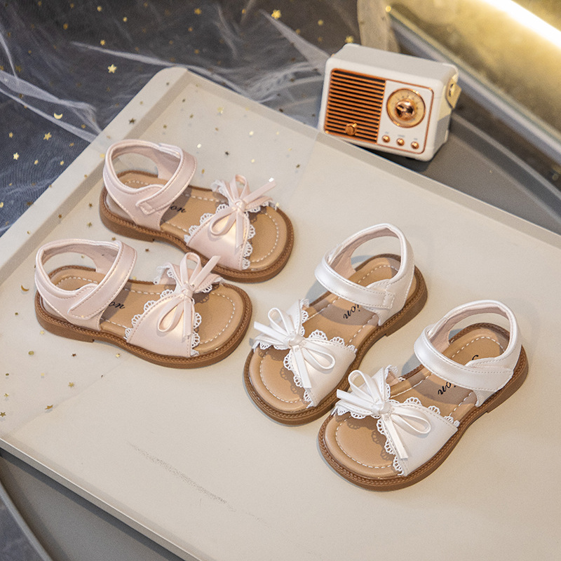 Sandalias para niñas 2025 nuevo estilo verano niña bebé casual zapatos de playa de suela blanda zapatos de princesa con lazo de estilo occidental para niños