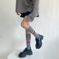 ストライプのふくらはぎの靴下の女性の千金風の英倫風の透かし彫りの網の目の黒い白い灰色の通気性はやせている学院の風の中で筒の靴下の潮を現します。
