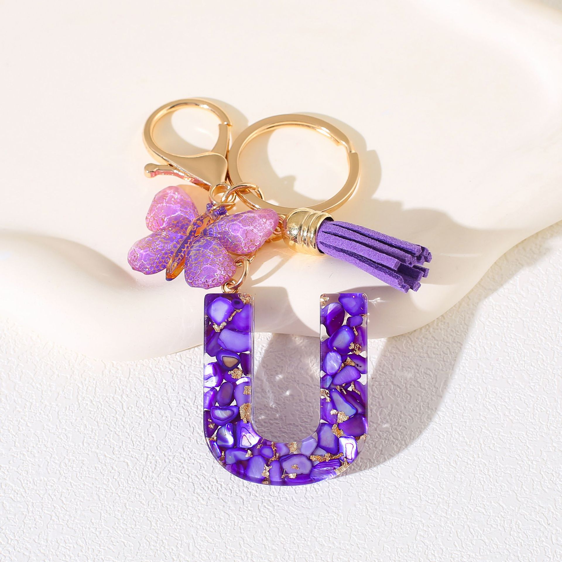 Fábrica directa de Yiwu accesorios de resina de goteo de embalaje llavero anillo de metal letras mariposa brilla colgante damas