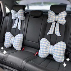 車のヘッドレストの腰はネットの赤い格子の蝶結びのリボンに寄りかかっています。