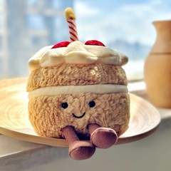 Jellycatと同じモデルのイチゴケーキのぬいぐるみのぬいぐるみケーキのデザートの人形が誕生日プレゼントを飾っています。