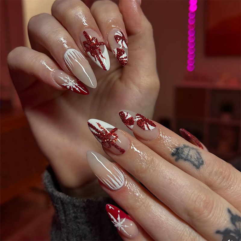 Medium almond-shaped glossy Christmas manicure with red glitter, French-style nails, snowflakes, bows, ribbons, and press-on nails