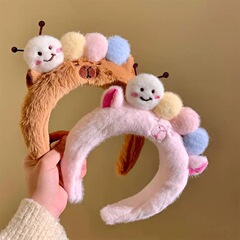 かわいいぬいぐるみの毛虫のカチューシャの女性の顔を洗って化粧します。