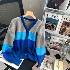 外は青い色のストライプvネックのニットのセーターのコートを着ています。