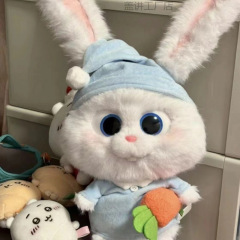 ウサギのボスのぬいぐるみのぬいぐるみのかわいいウサギの人形のパジャマは大根のウサギを抱いてかわいがります。