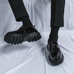 靴の男の明るい皮の黒色は高くなります。