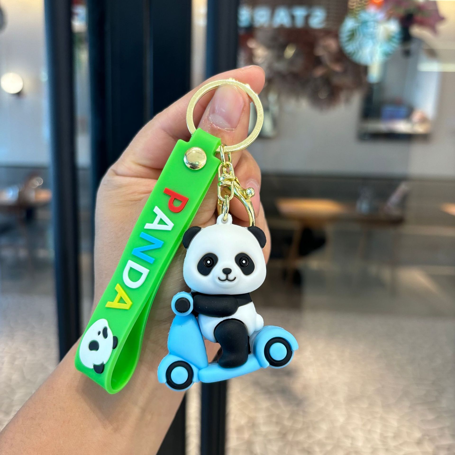 アニメは竹のパンダのキーホルダーを抱いてかわいいパンダのカップルの小銭入れを掛けます。