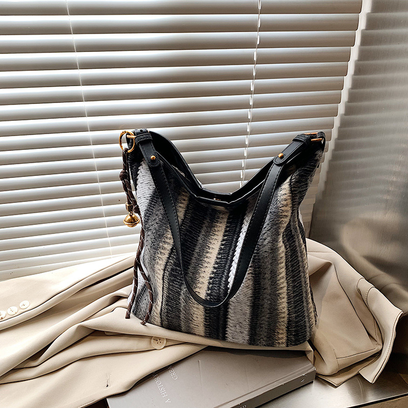 Bolsa de cubo de tendencia coreana a rayas, bolsa de hombro de gran capacidad, otoño y invierno 2025, nueva bolsa de mochila casual para mujeres.