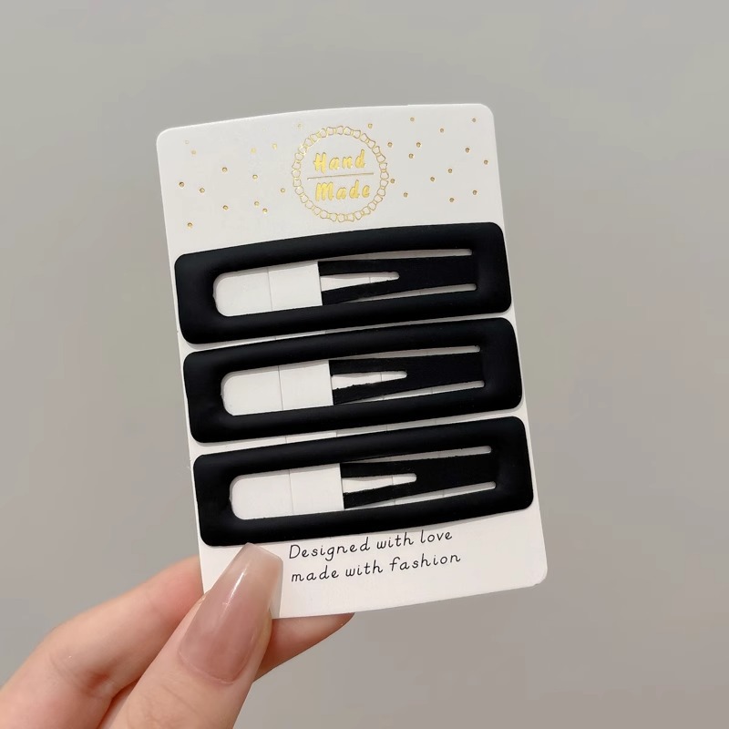 Clipper de cabello de metal negro de alto nivel, frente lateral de la mujer, cabello roto, boca de pato, tocado, clipper para el cabello