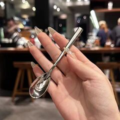 ステンレススプーンのサブネットの赤いコーヒーはスプーンをかき混ぜます。