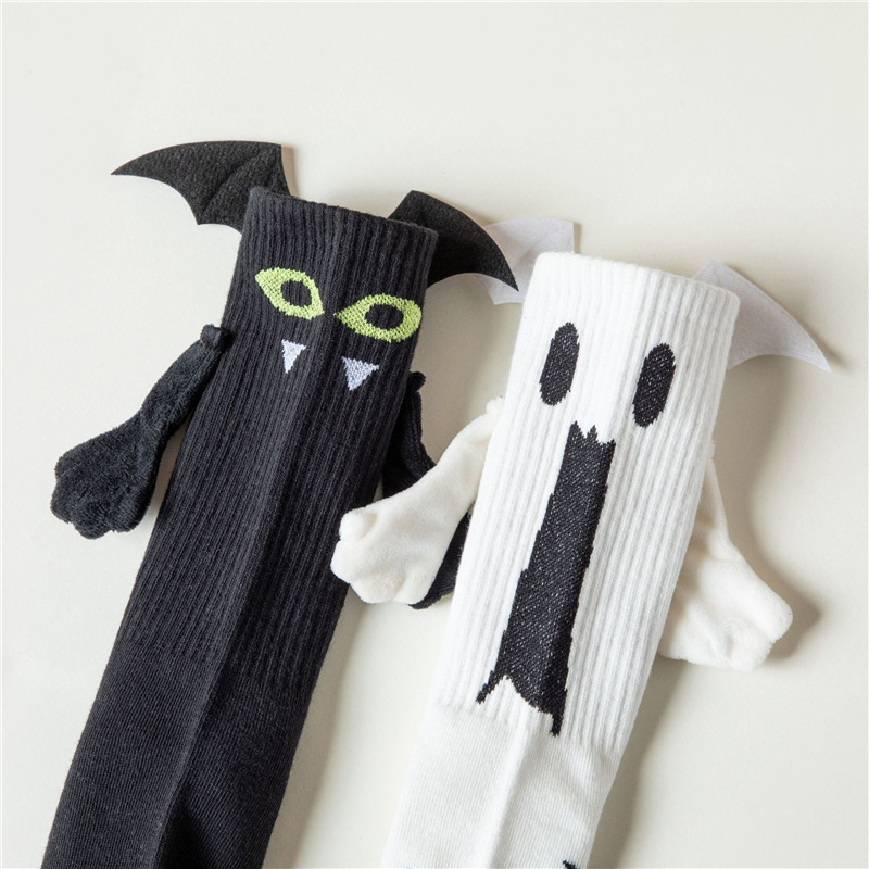 ハロウィーンの靴下の幽霊の磁気は手をつないで靴下を越えてアマゾンを越えてかわいいコウモリの靴下の中で靴下の綿をいじります。|undefined