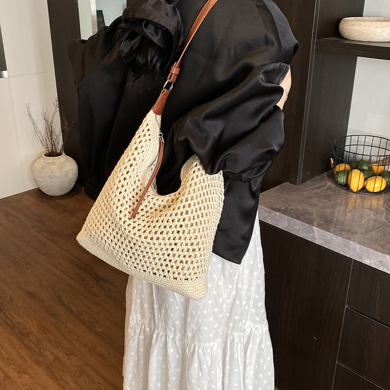 Venta caliente de verano nuevo producto bolsa tejida hueca para mujer 2025 bolsa de playa estilo vacaciones bolsa de paja de gran capacidad bolsa de cubo