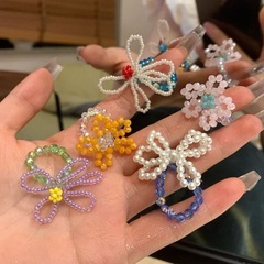 春夏の小さい米の玉の手織りの数珠は色の透かし彫りの花の指輪のカラーのアクセサリのドーパミンの新型にぶつかります。