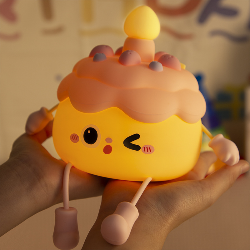 創意的な誕生日ケーキの小夜灯のベッドの上に飾られています。|undefined