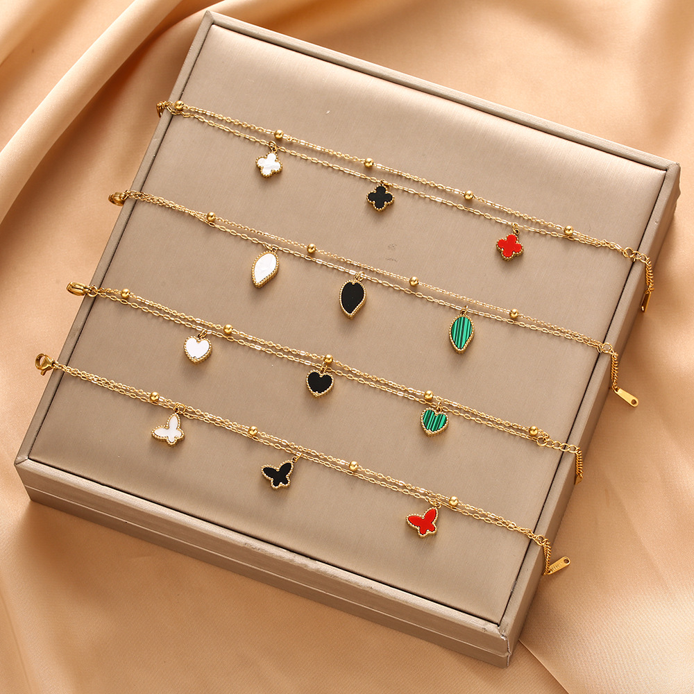 Pulsera de trébol de acero titanium vendedora caliente transfronteriza europea y americana con incrustaciones de concha pulsera colgante pulsera de diseño avanzado sin desvanecimiento al por mayor