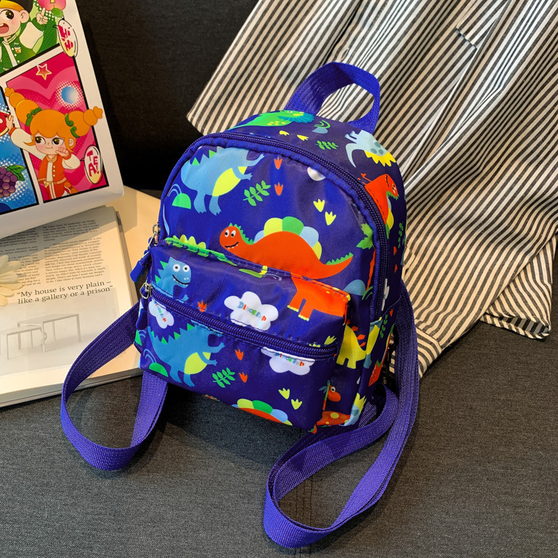 Mochila nueva al por mayor 2025, mochila de tela Oxford con diseño de dinosaurio de dibujos animados, mochila pequeña de gran capacidad para actividades al aire libre y ocio.