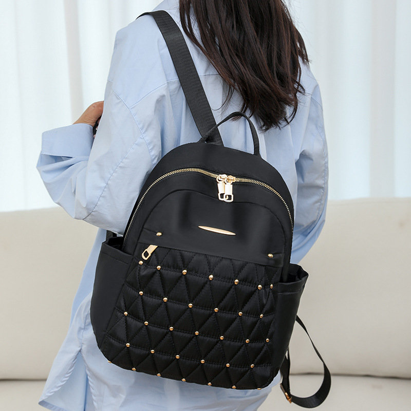 Mochila de nailon en relieve de moda para mujer 2025 nueva mochila para mujer versión coreana de la mochila de viaje de gran capacidad salvaje para mujer